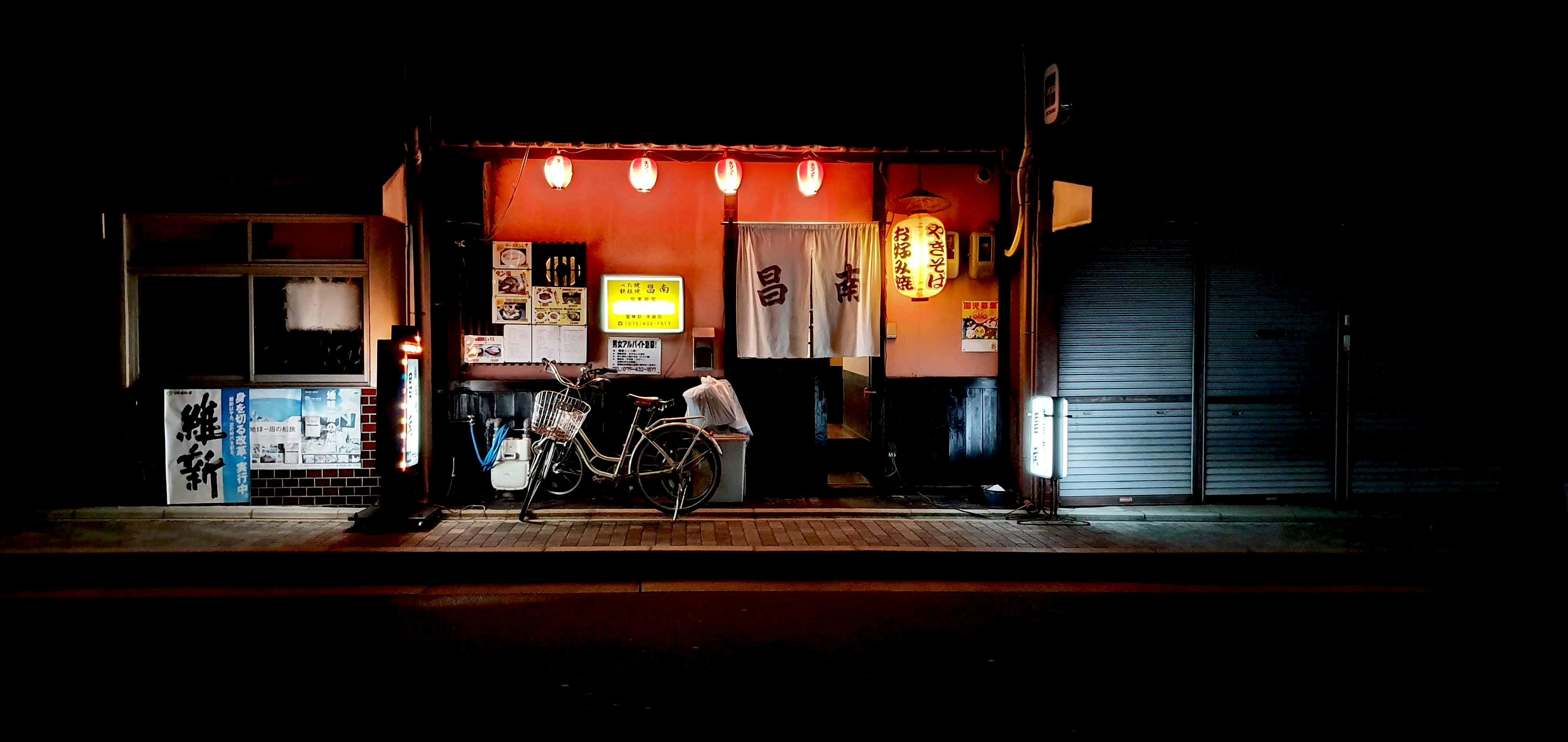 a bicycle parked in front of a building at night