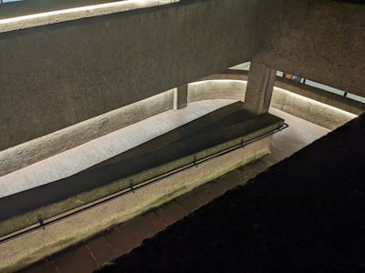 Wide shot of a gallery walkway with restored concrete surfaces and clean lines.