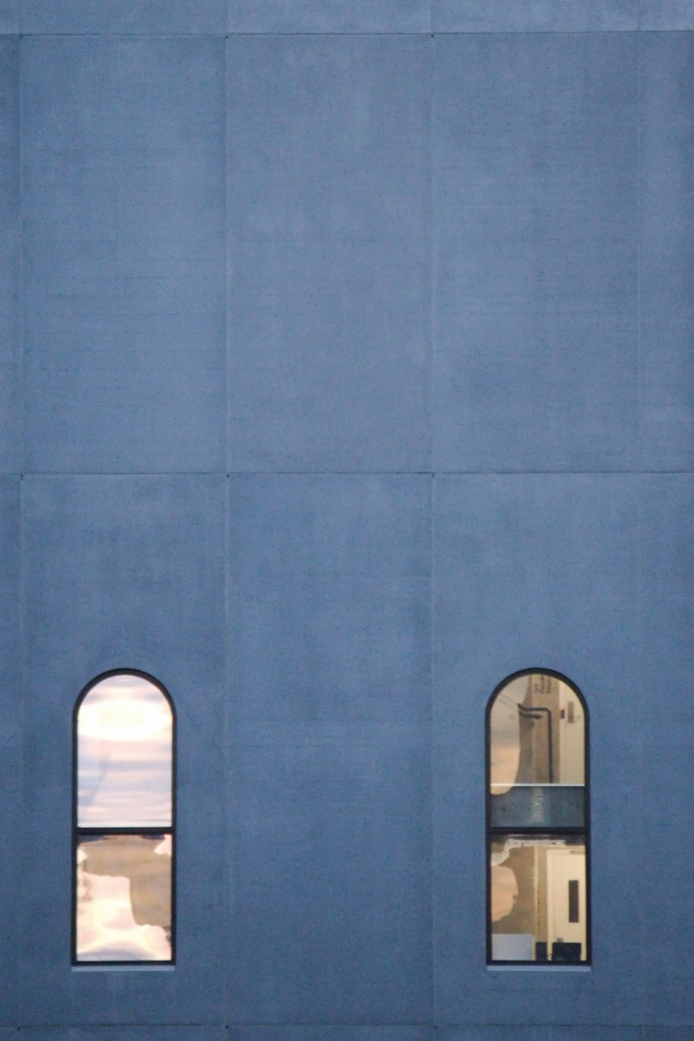 a blue building with three windows and a clock