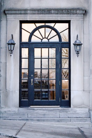 a black door with a window and a light on the side of it