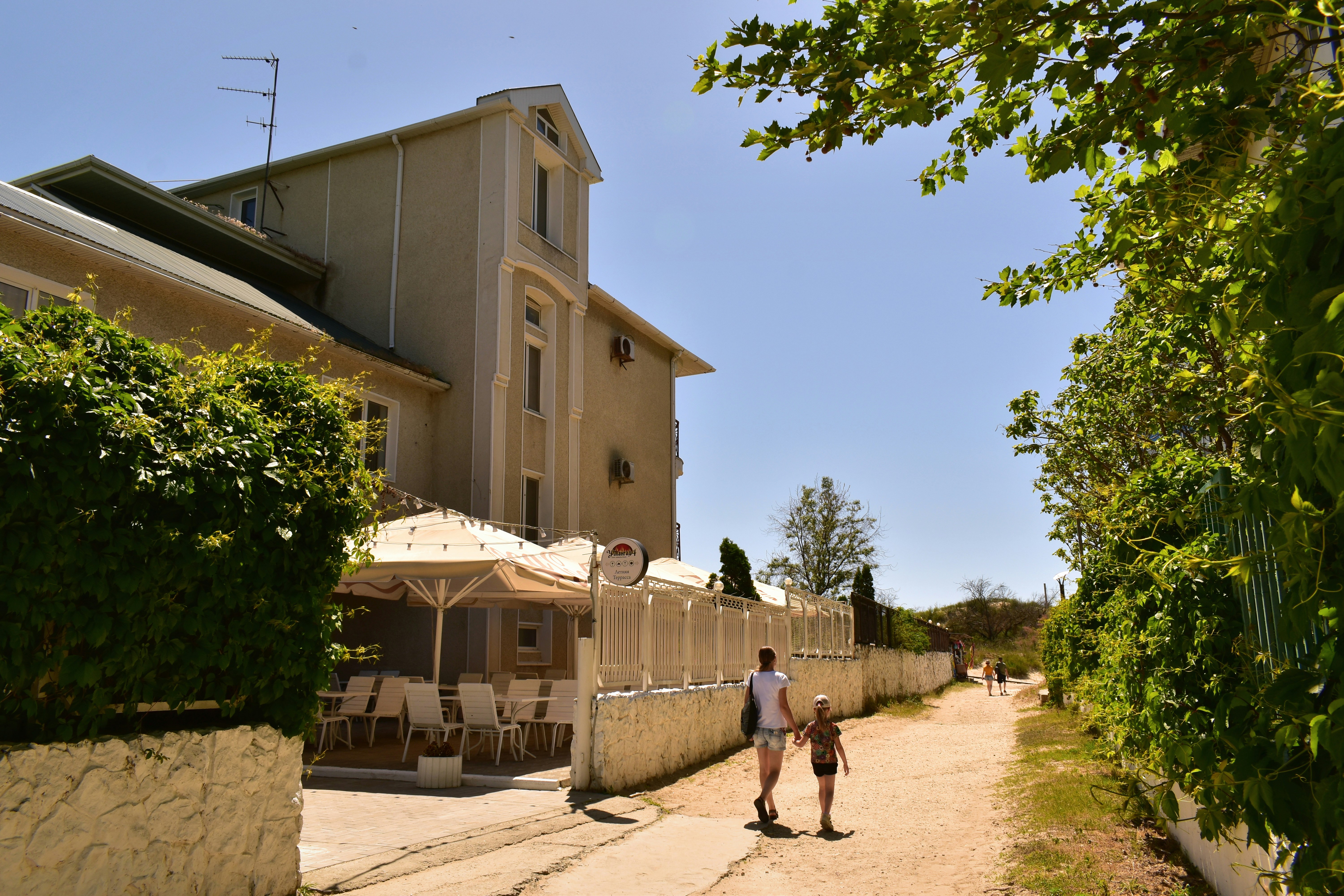 a man and a child walking down a dirt road, 