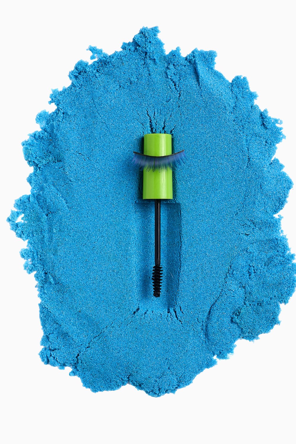 a blue powder with a green brush on top of it