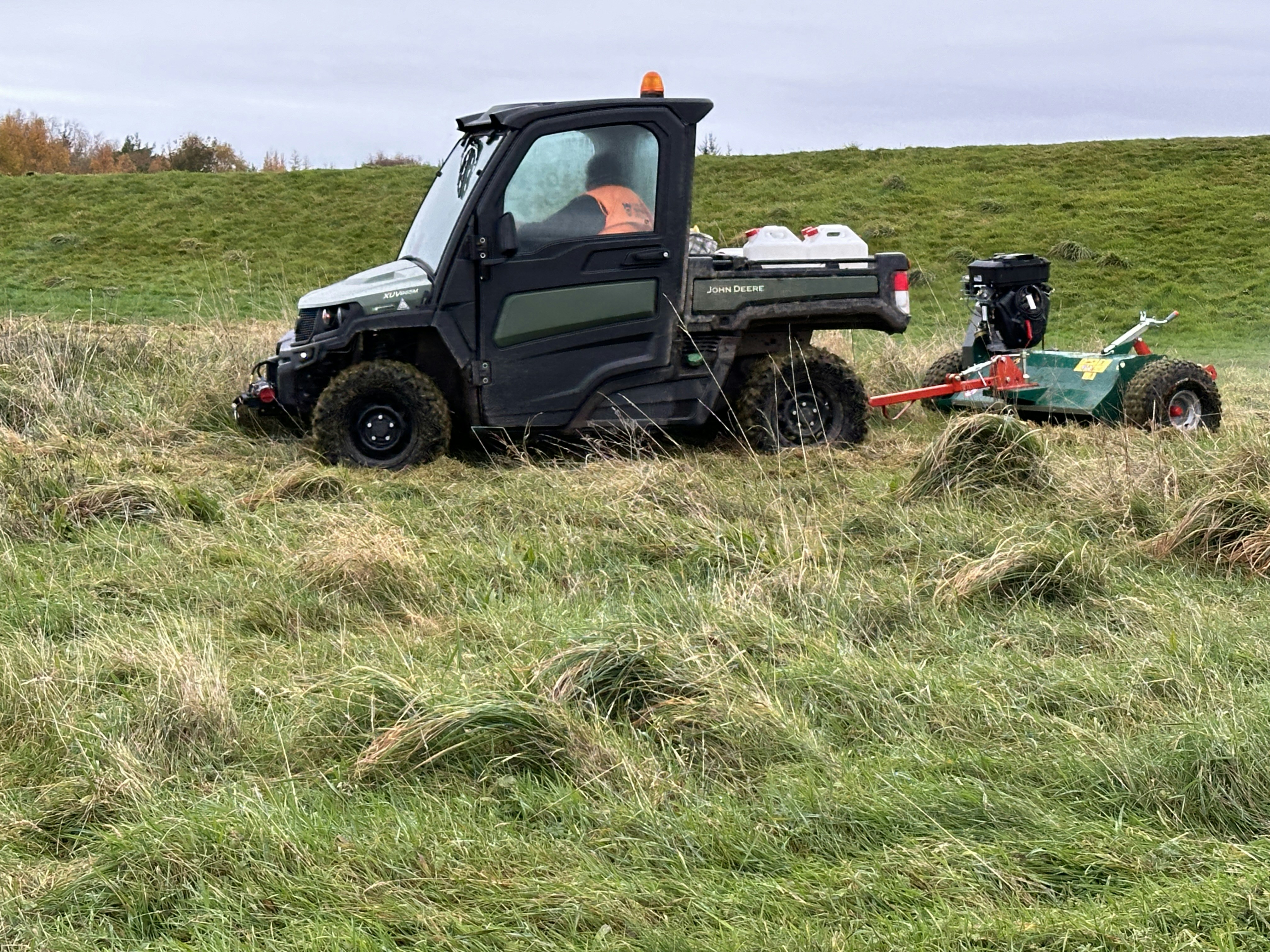 Lawn mower cutting thick grass on a property