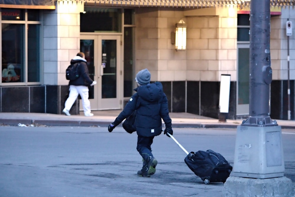 a person pulling a suitcase down a street