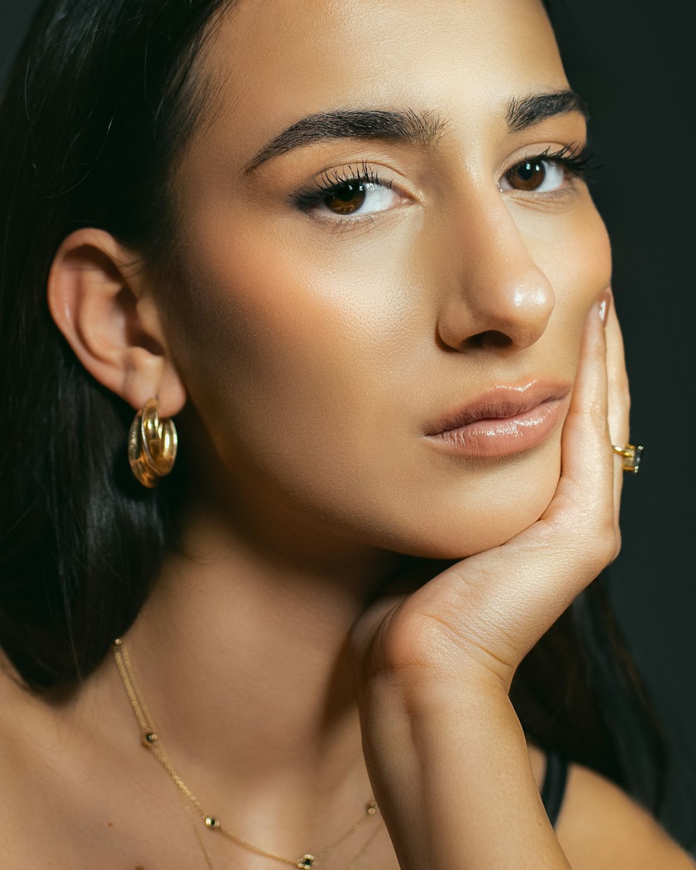 a woman with a necklace and earrings on her neck