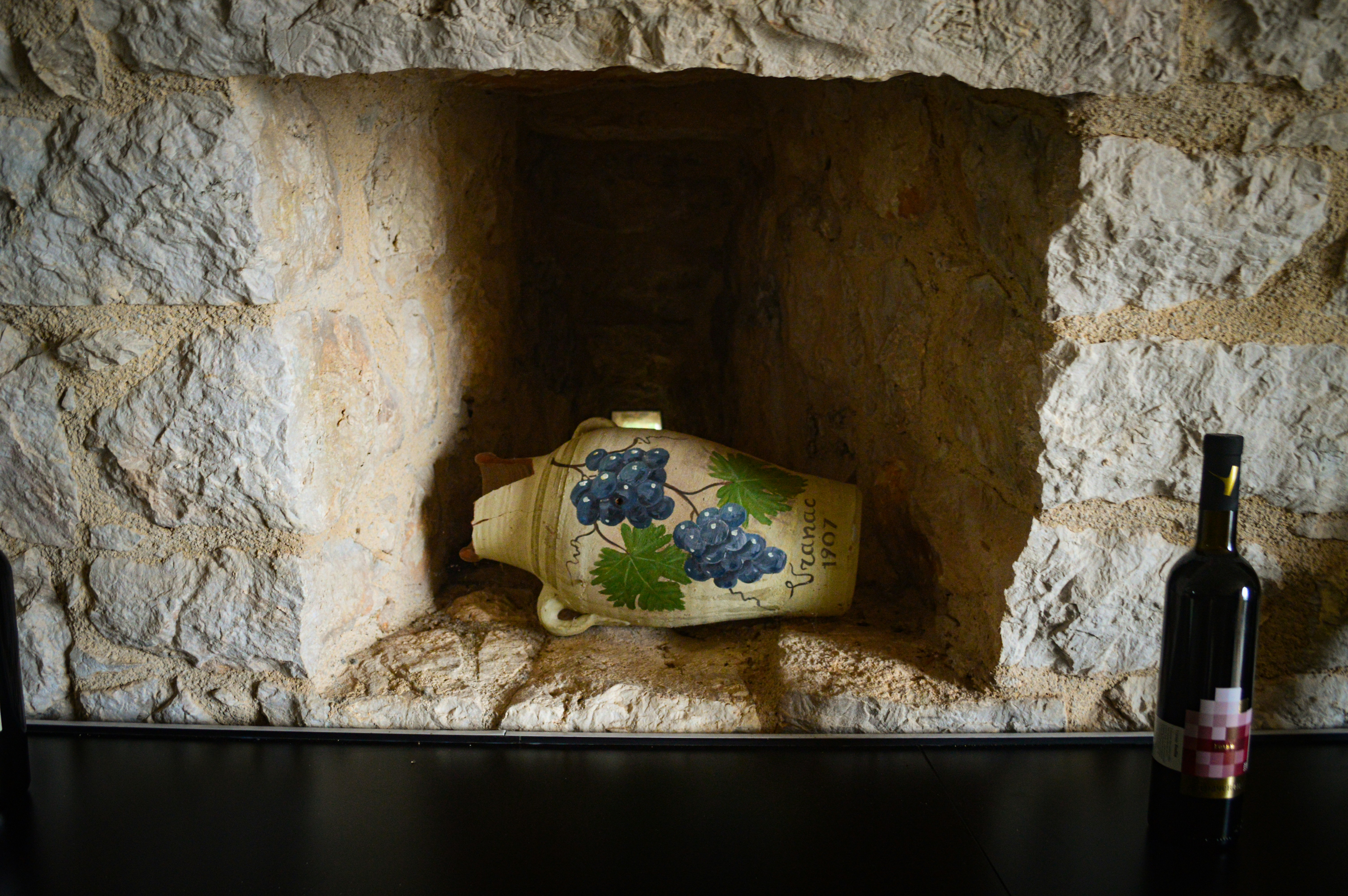 eine Flasche Wein, die auf einem Tisch neben einer Vase steht