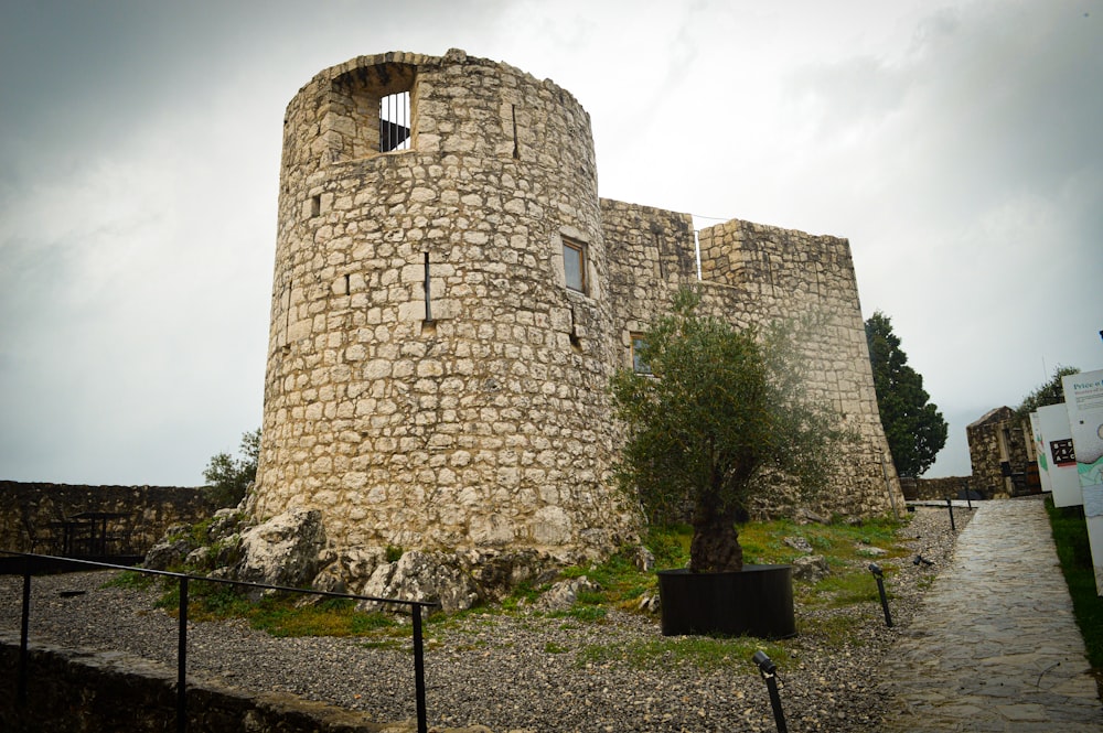 a stone castle with a tree in front of it