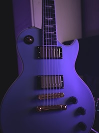 Sleek electric guitar with glossy finish and chrome hardware under stage lights.