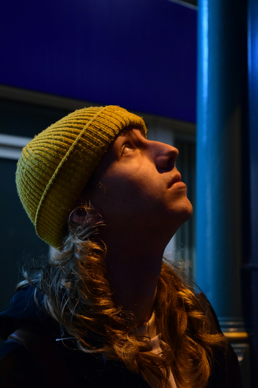 a woman wearing a yellow hat looking up