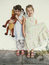 Happy children playing with stylish toys and wearing chic outfits in a bright room.