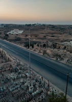 Sunset view of the desert landscape near Tamgroute with pottery pieces arranged outdoors, highlighting their earthy tones.