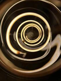 Close-up of hypnotic spirals glowing softly against a dark background, inviting trance and surrender.
