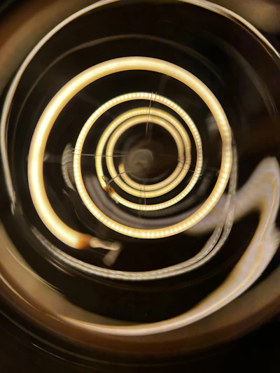 A serene golden spiral pattern softly glowing over a beige textured background, evoking calm and transformation.