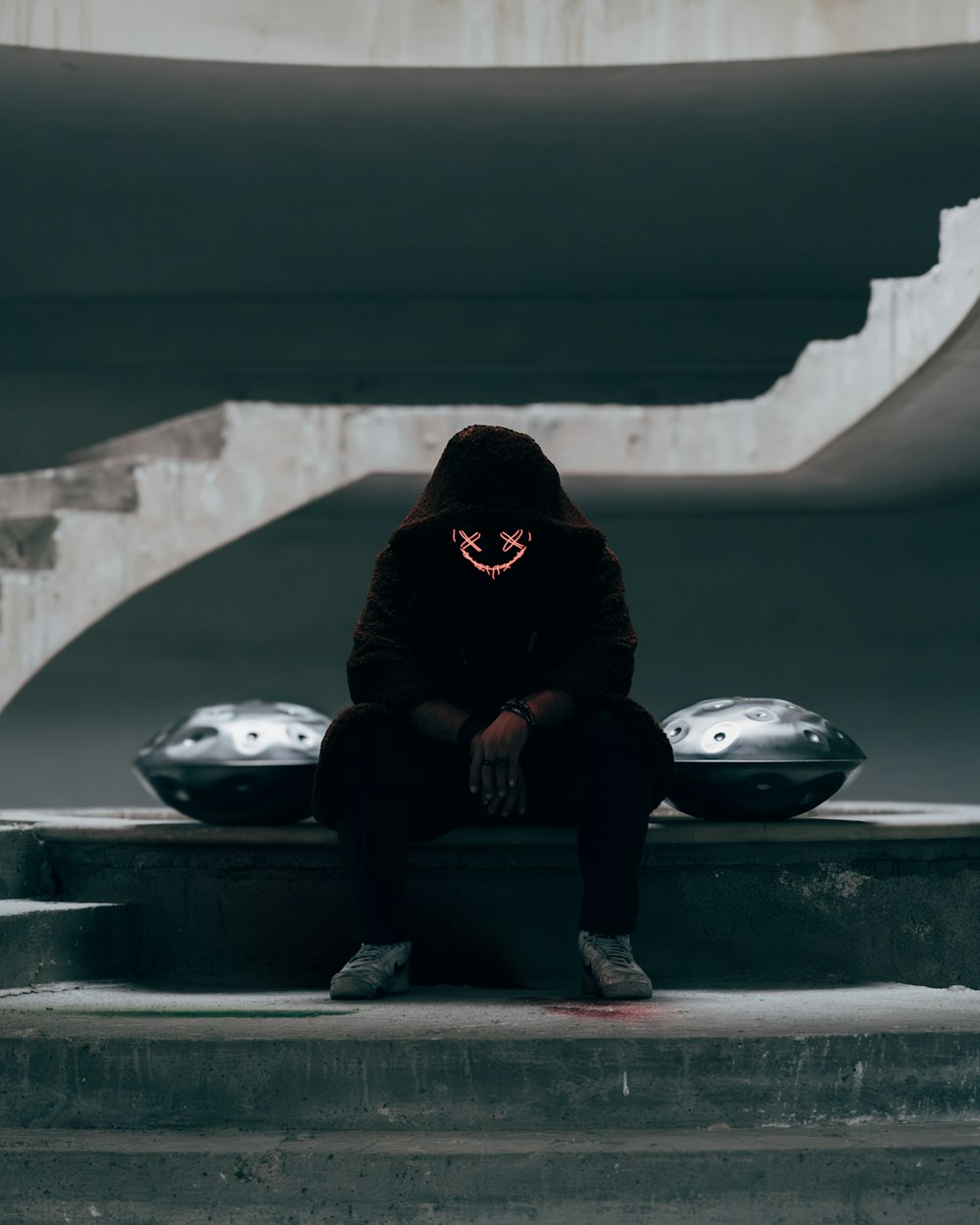 a person sitting on a ledge with a neon mask on