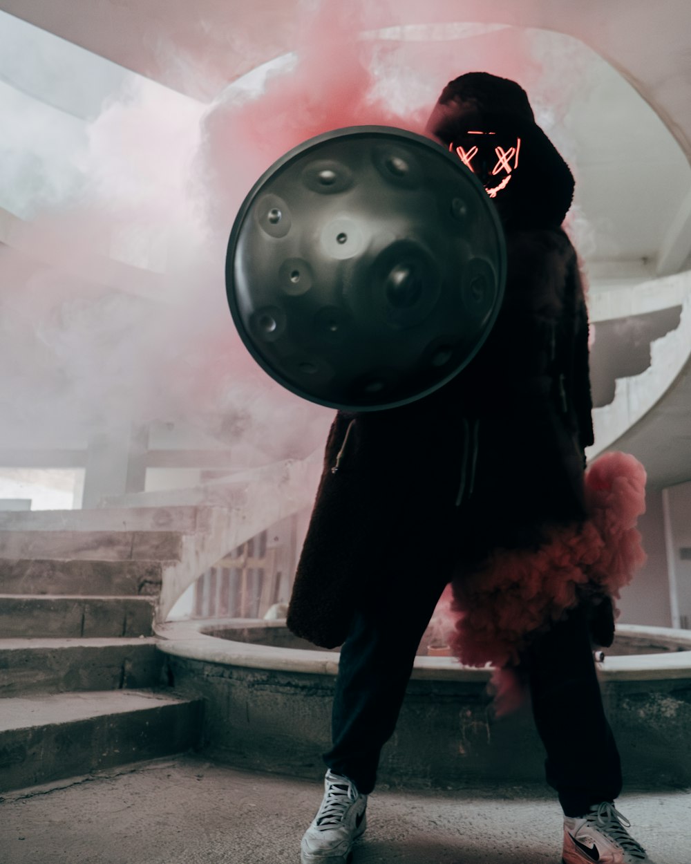 a man in a black coat holding a large object