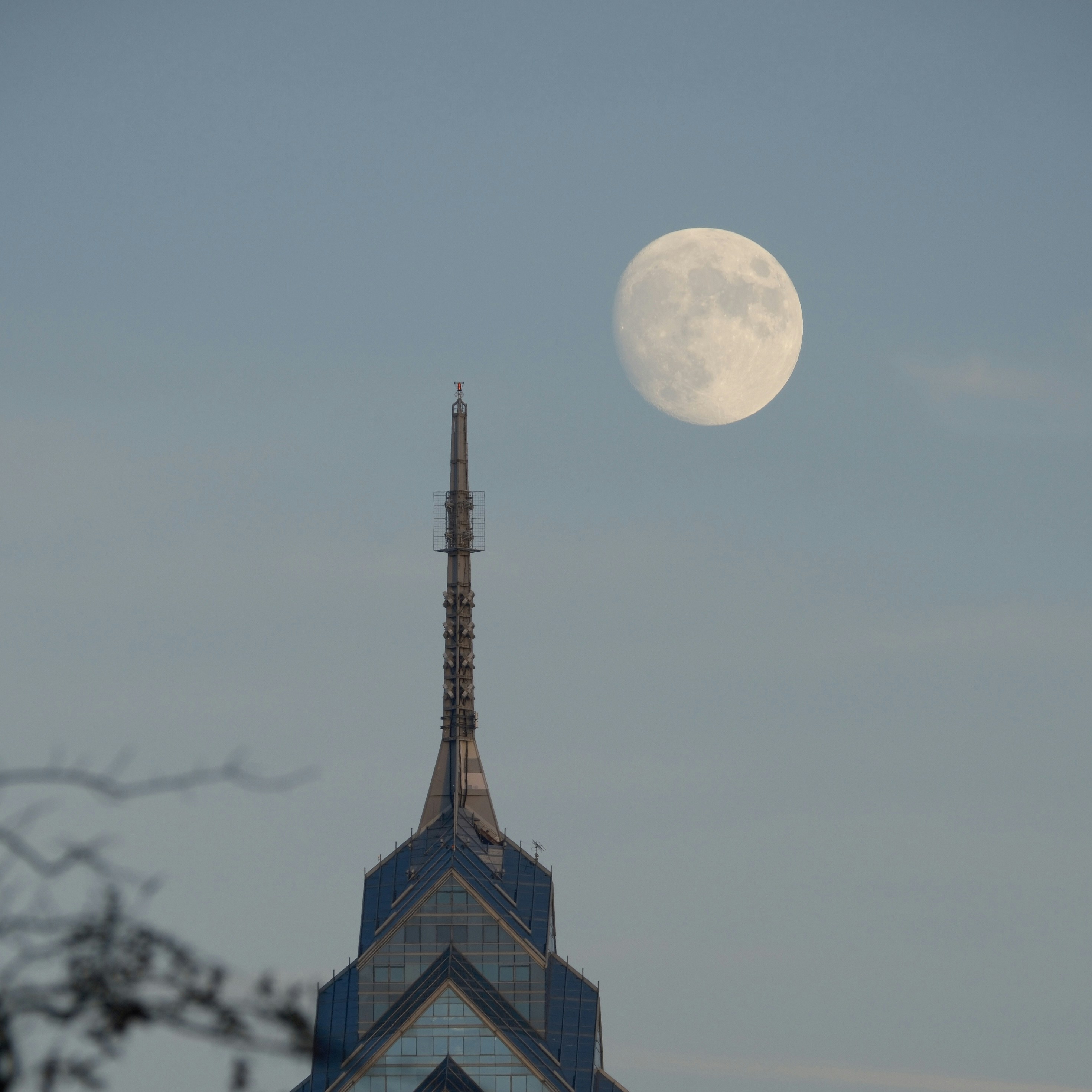 A very tall building with a very large moon in the sky photo – Free ...