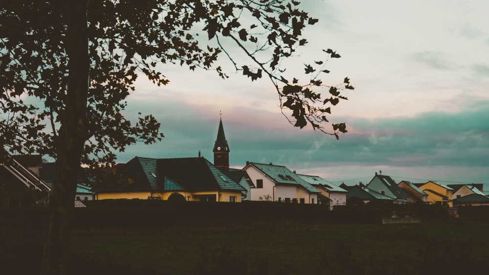 a row of houses with a church steeple in the background