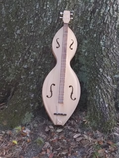 a wooden instrument sitting next to a tree