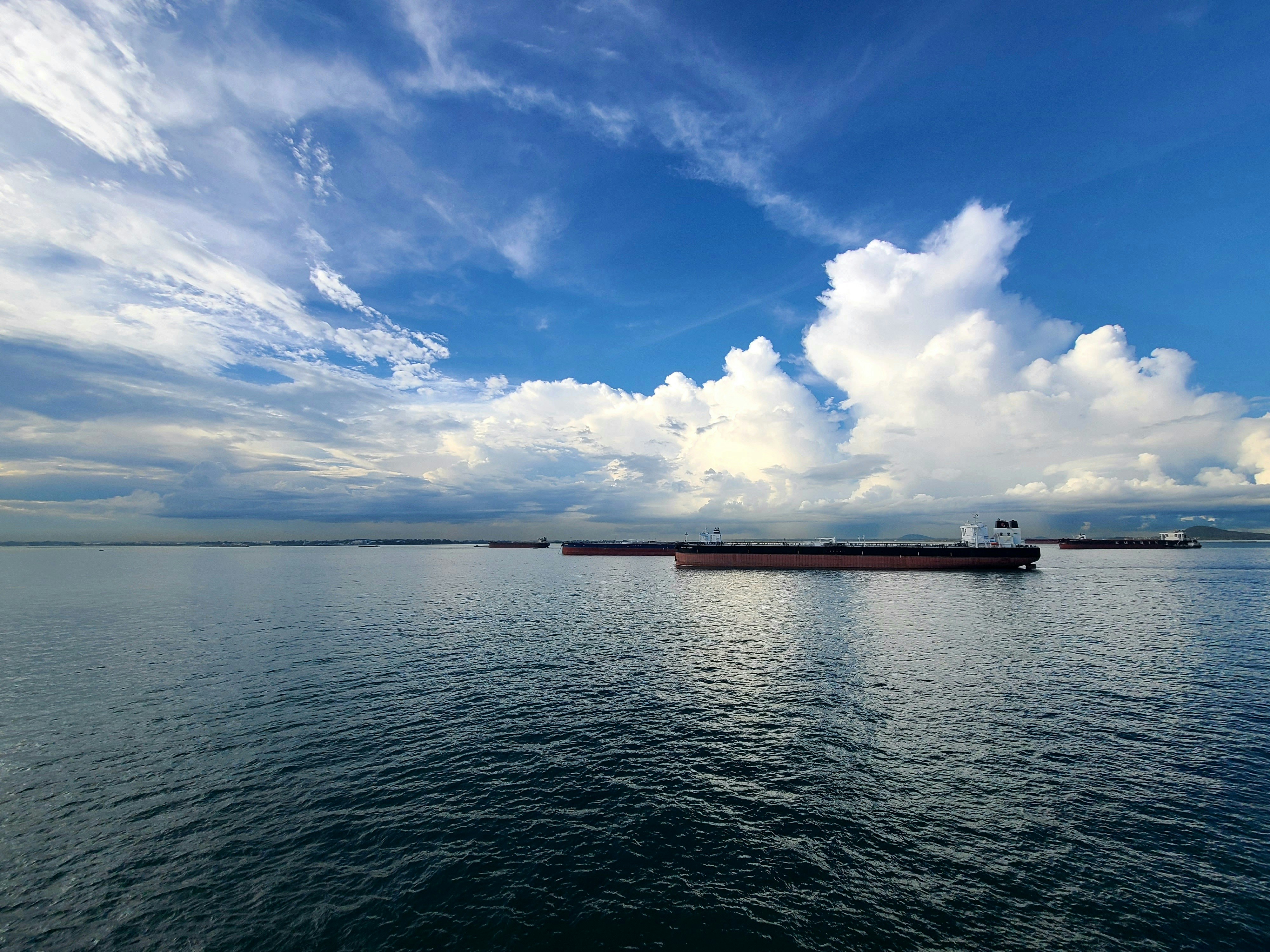 A large cargo ship sailing across a large body of water photo Free