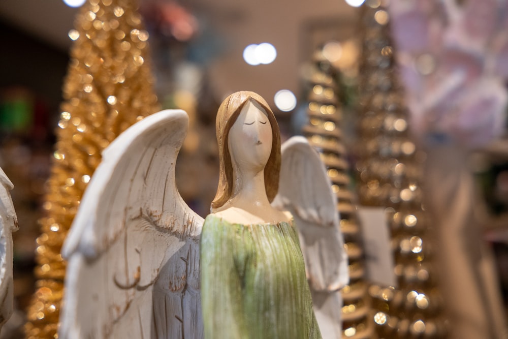 a statue of an angel in front of a christmas tree