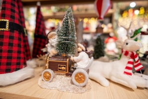 A handcrafted reindeer plush with delicate antlers perched next to a stack of children’s storybooks.