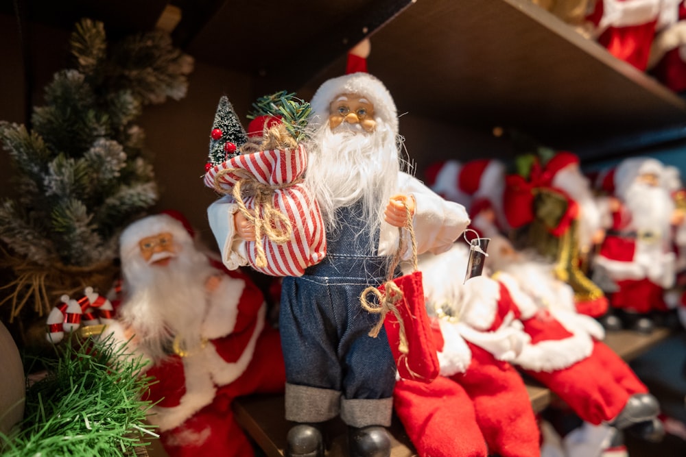 a group of santa clause figurines sitting on top of a shelf