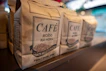 Bags of carefully packed G-1 graded coffee ready for export, marked with the caféluz logo.
