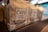 Several brown paper bags of coffee labeled with bold text 'Café Moído na Hora' and 'Grãos Selecionados' are neatly arranged on a shelf. The focus is on one bag, with others visible in soft focus in the background. The setting is likely a market or store with subtle lighting and a blurred backdrop.