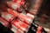 Several red cans with the Coca-Cola logo are stacked together inside a metallic container. Some bottles are also visible, suggesting a storage or cooling environment.