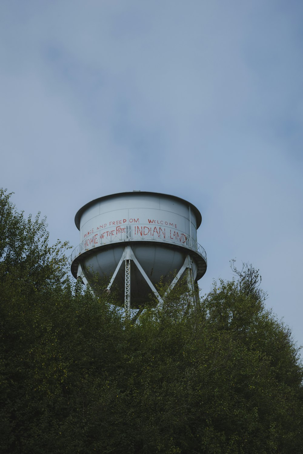 a water tower with trees in the foreground