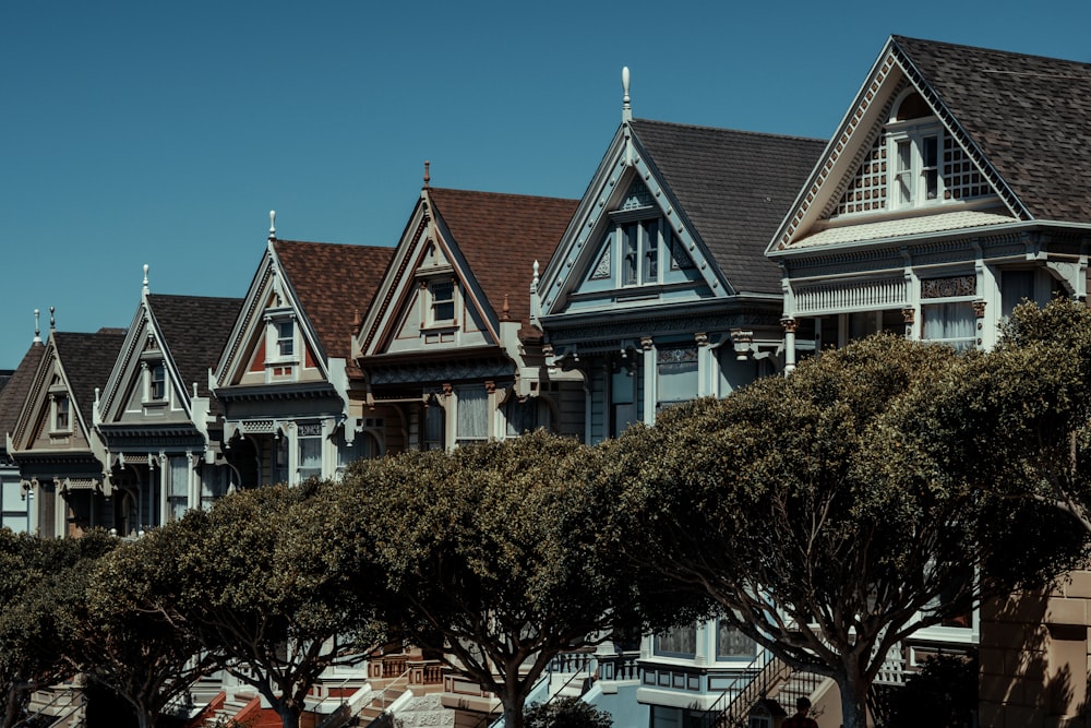 a row of houses with trees in front of them