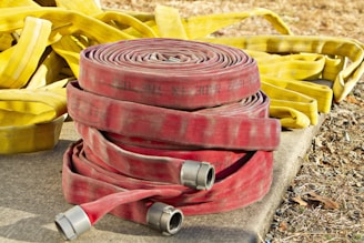 a pile of fire hoses sitting on top of a cement slab