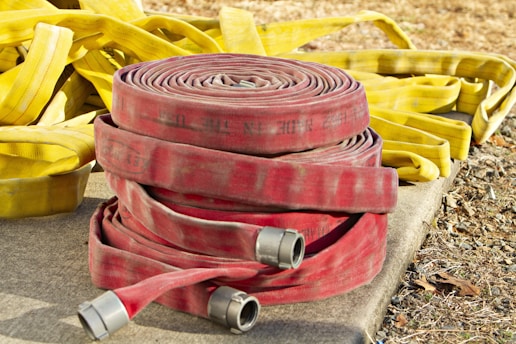 a pile of fire hoses sitting on top of a cement slab