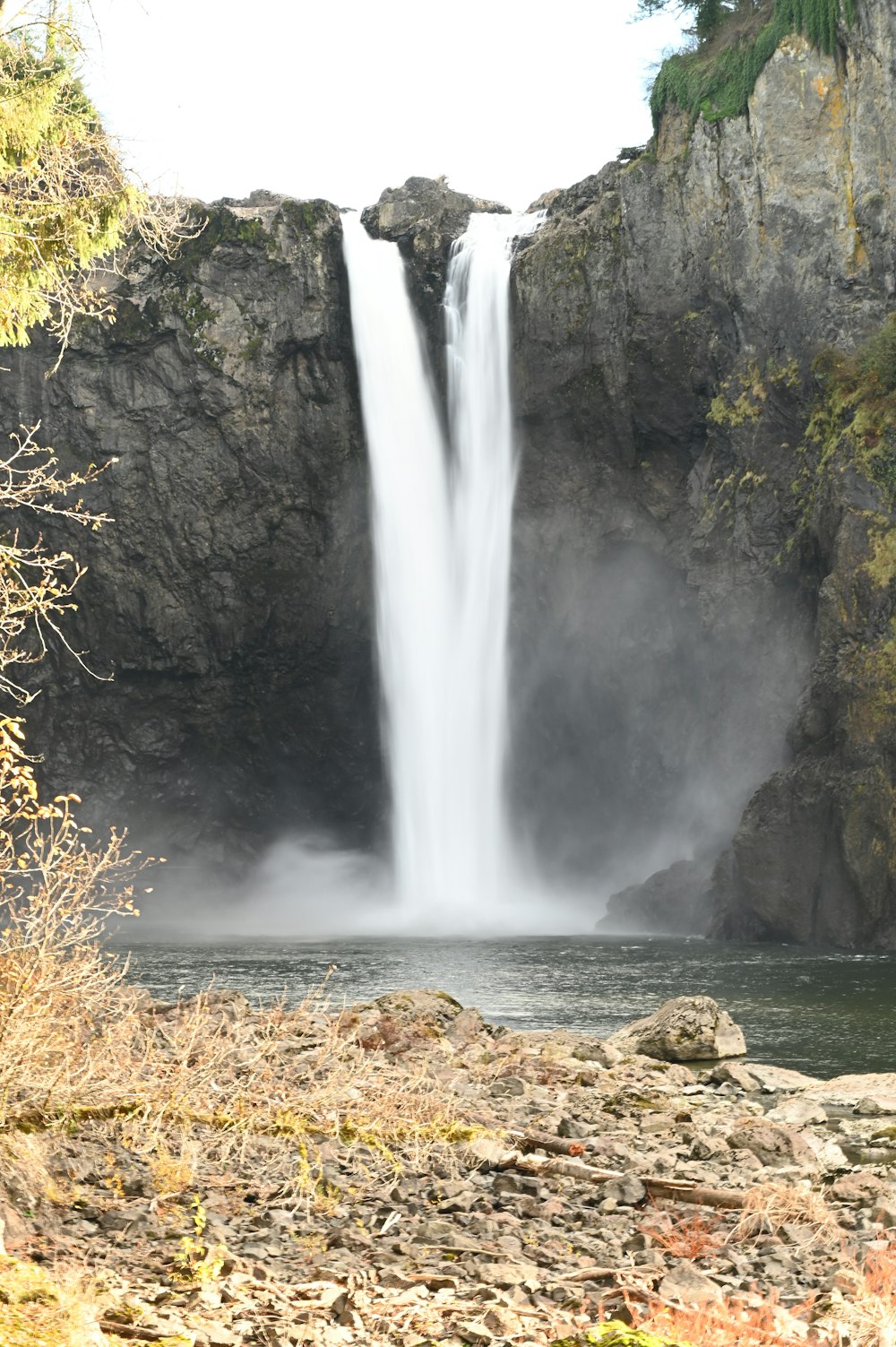 a large waterfall with a man standing in front of it