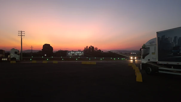 Evening view of Agronexo’s parking area illuminated with soft lighting, showing trucks resting.