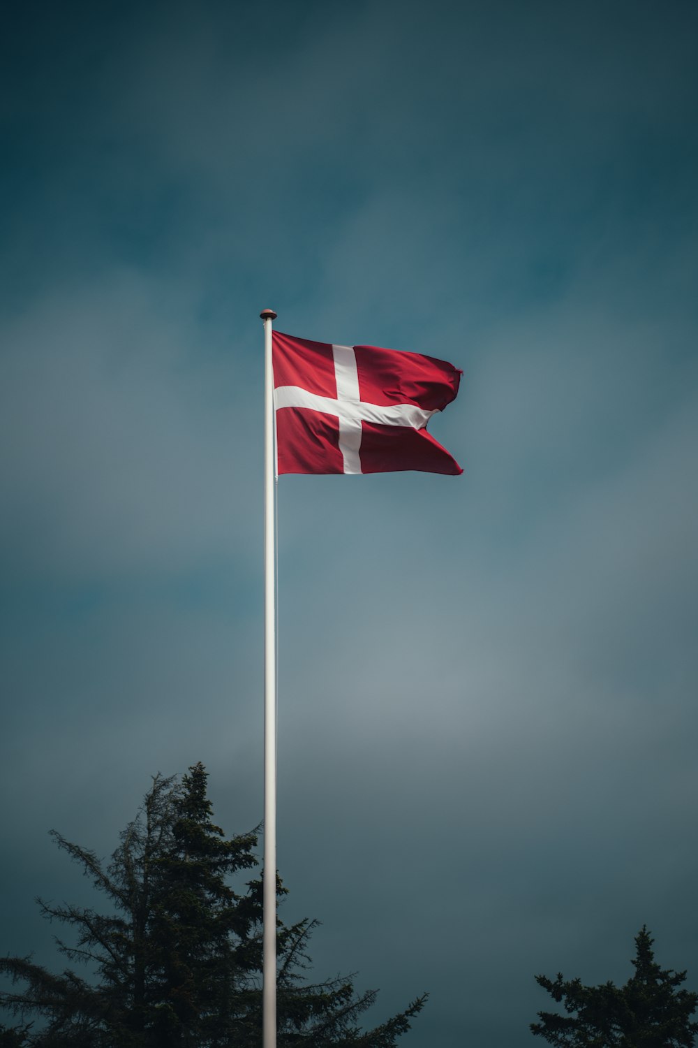 a red and white flag flying in the wind