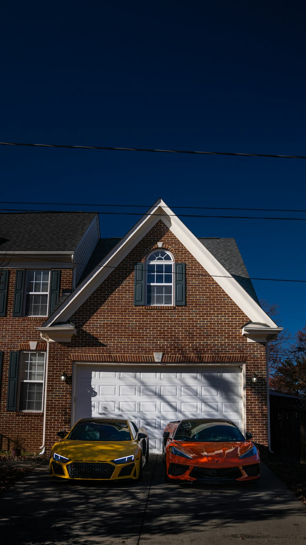 two cars parked in front of a brick house