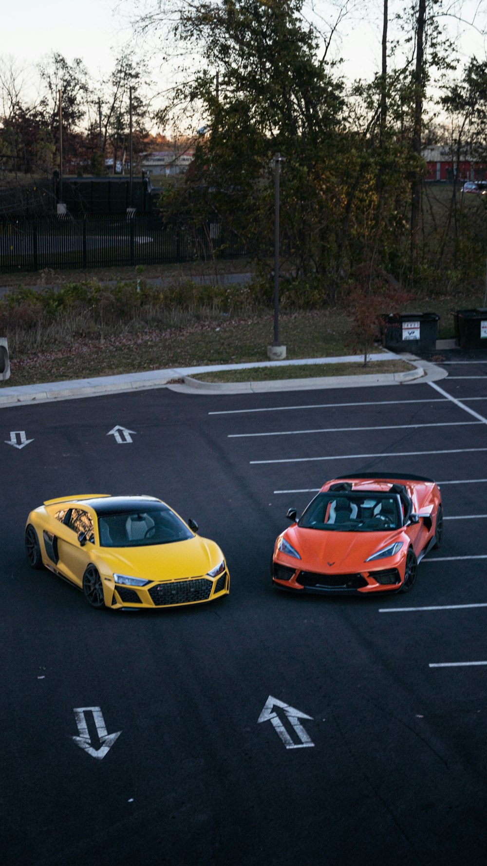 two cars parked in a parking lot next to each other