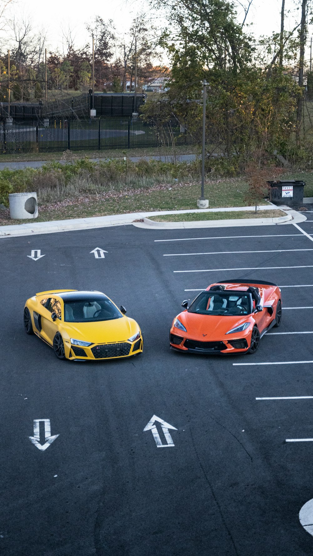 two cars parked in a parking lot next to each other