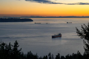 Sunset view over the Nile River with cargo ships passing by.