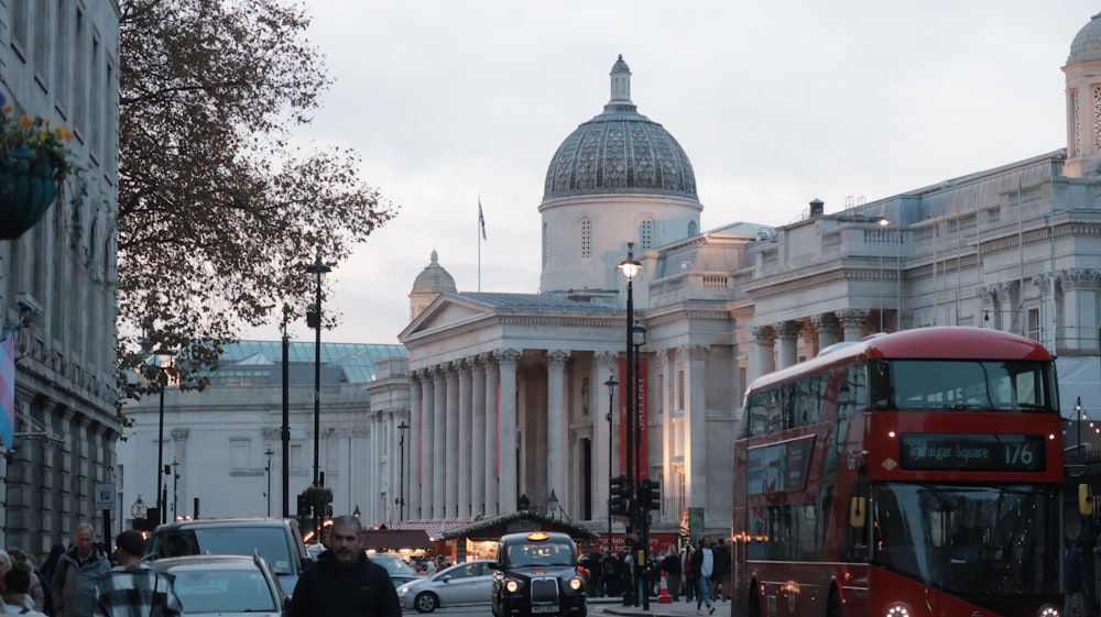 a red double decker bus driving down a street