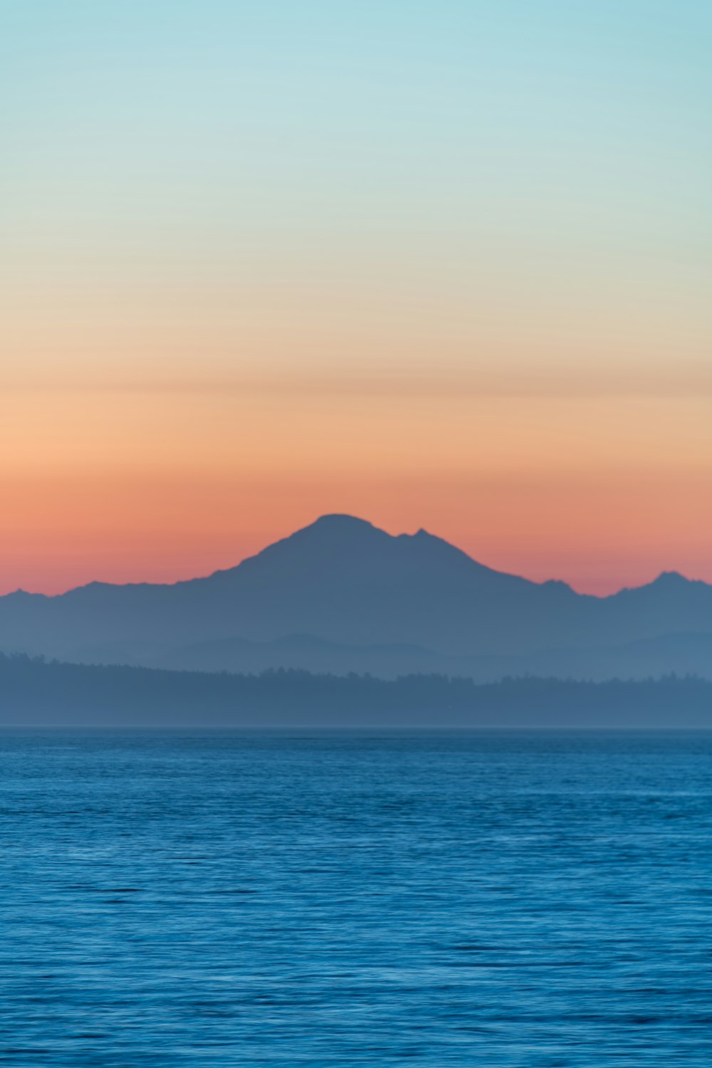 una gran masa de agua con montañas al fondo