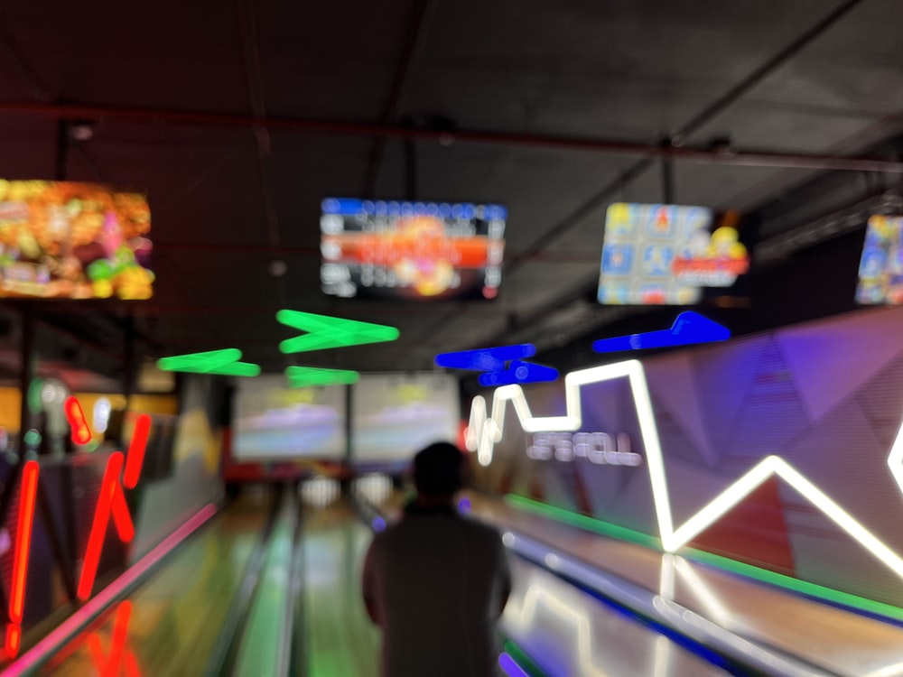 una foto borrosa de una persona jugando a los bolos en una bolera