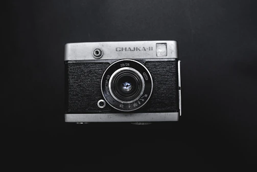 Close-up of a vintage film camera on a black background.