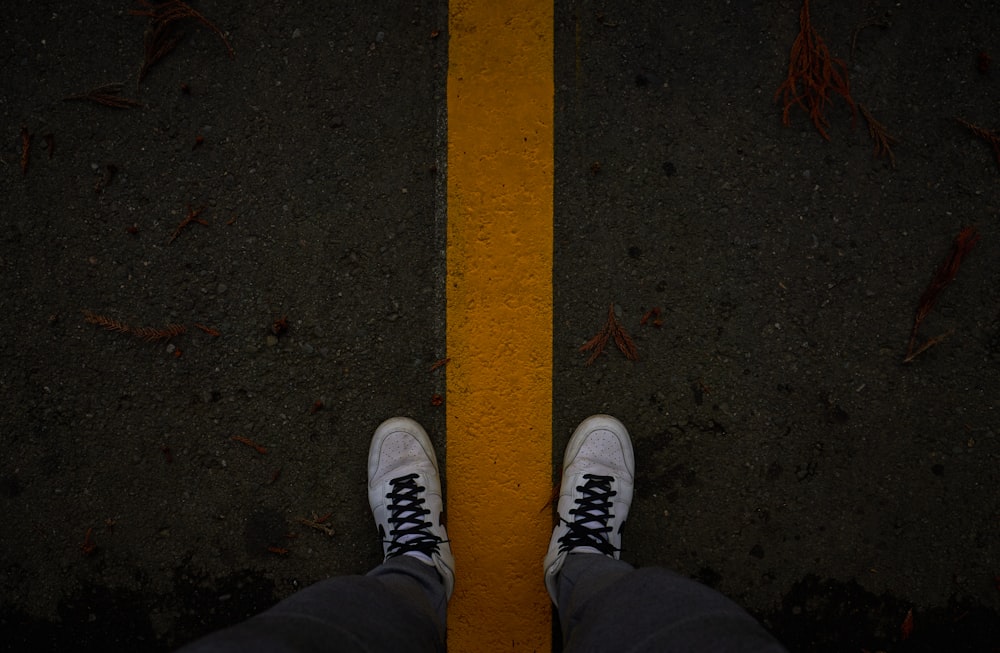 a person's feet standing on a yellow line