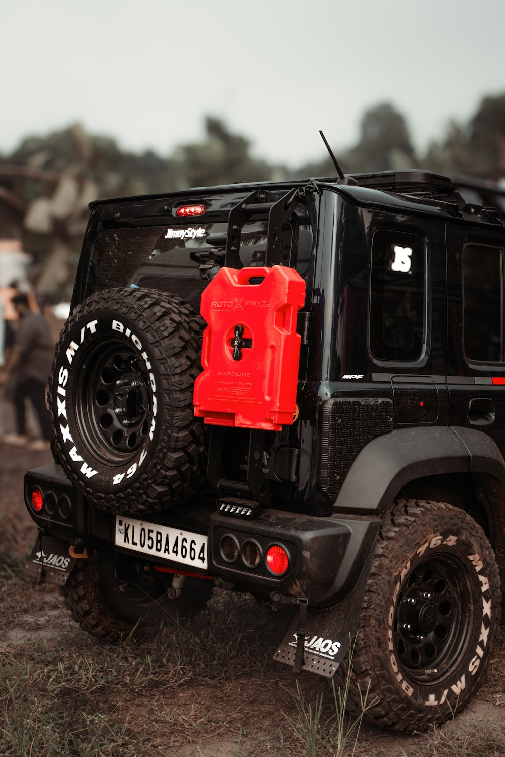 Ein schwarz-roter Jeep parkt auf einem Feldweg
