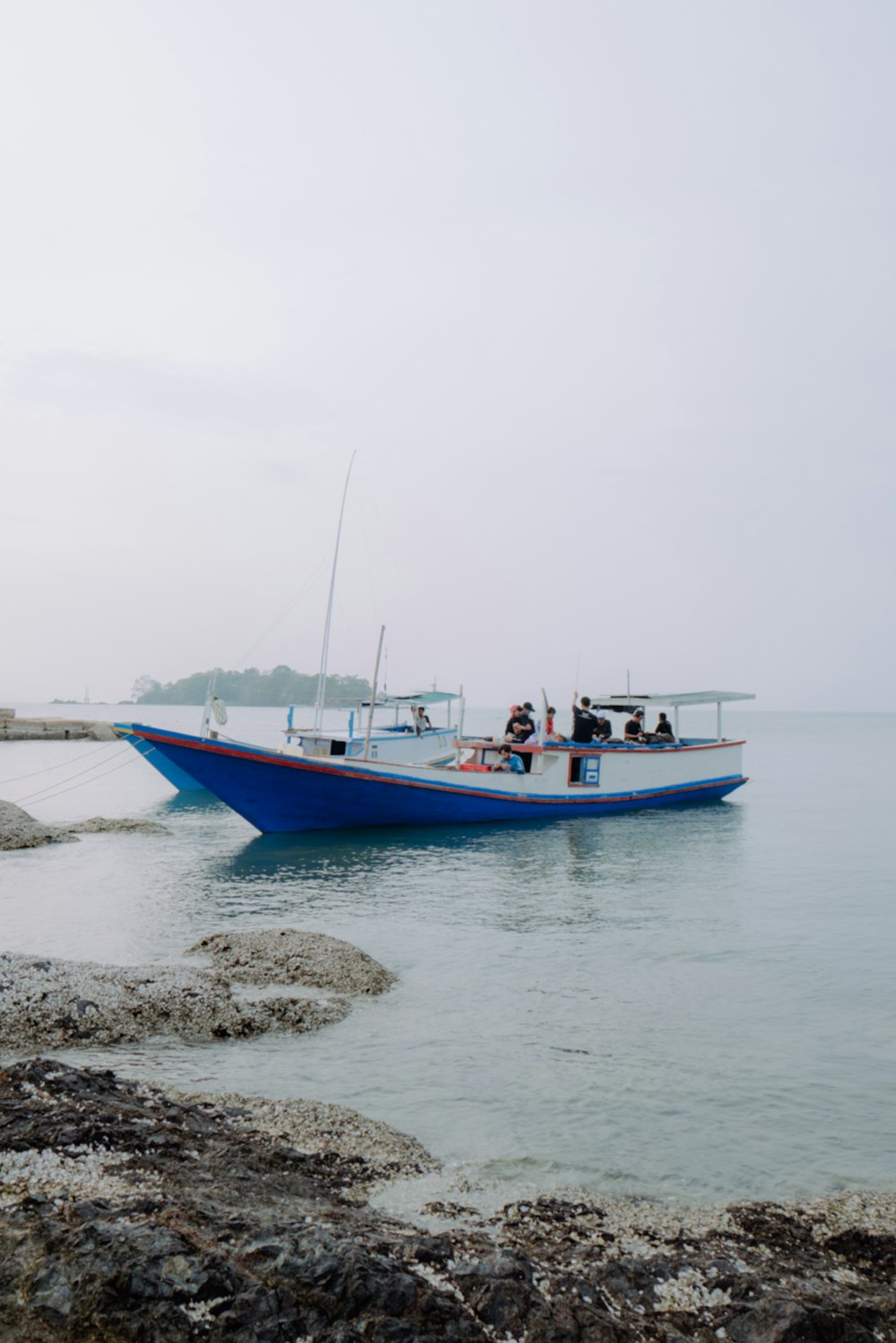 a blue boat floating on top of a body of water