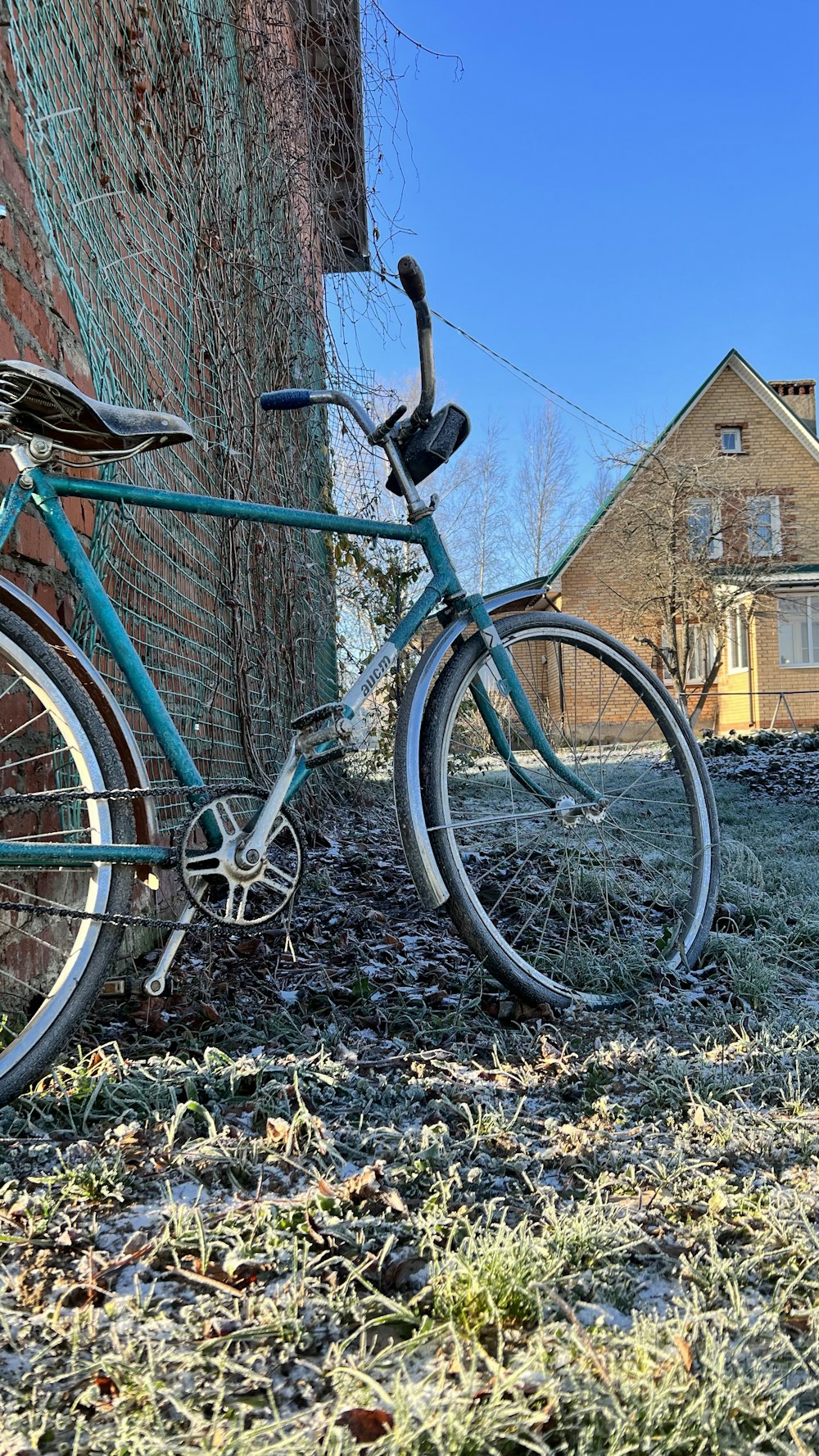 a blue bicycle parked next to a brick building