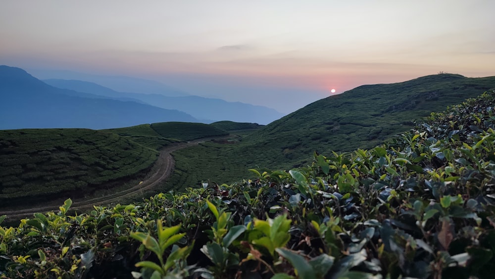 the sun is setting over the mountains in the distance