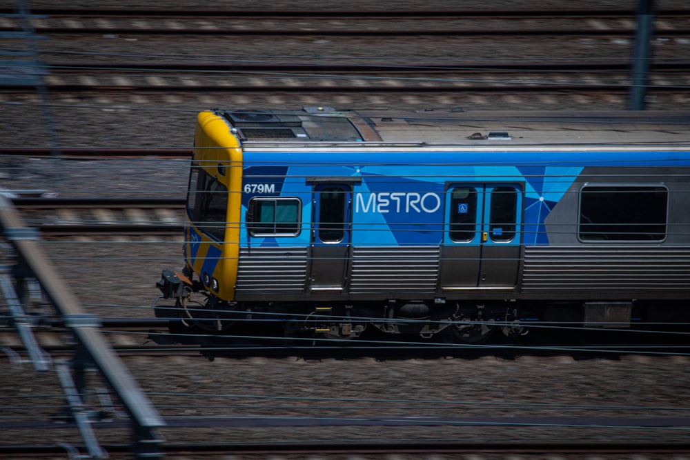 a blue and silver train traveling down train tracks